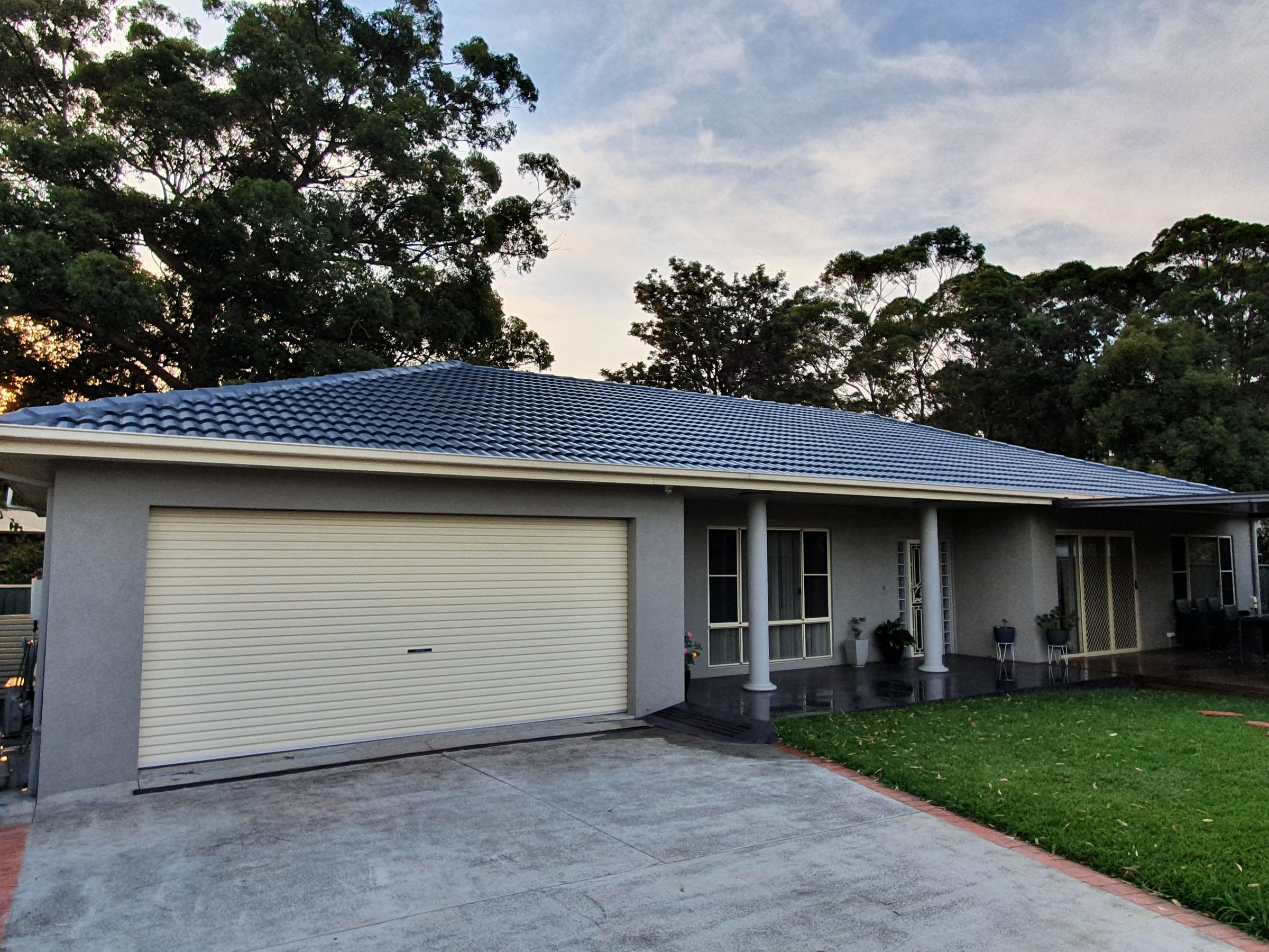 Rendered home with double garage and a restored charcoal tiled hip roof