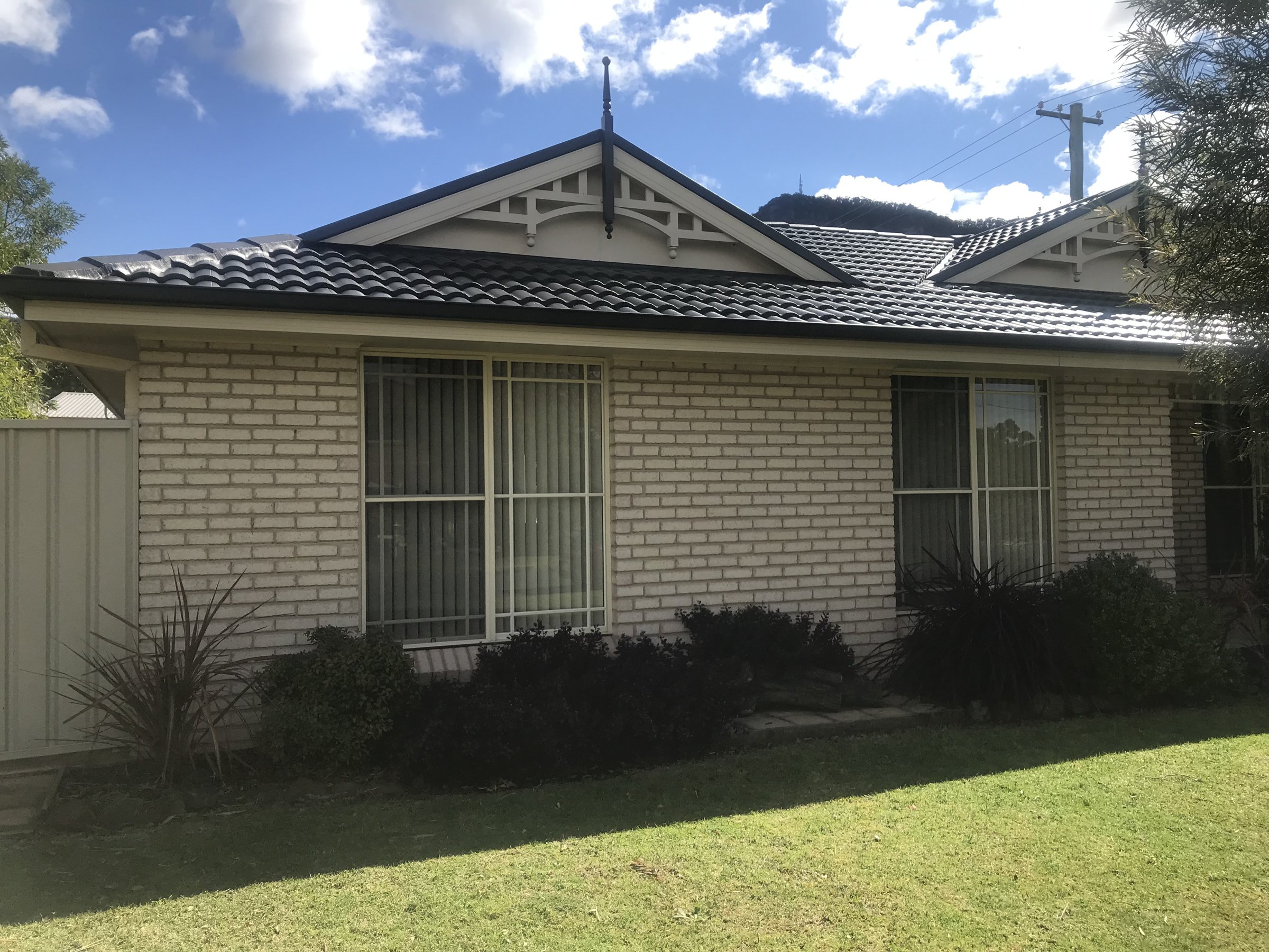 Cream brick home with a charcoal tiled roof and gable feature